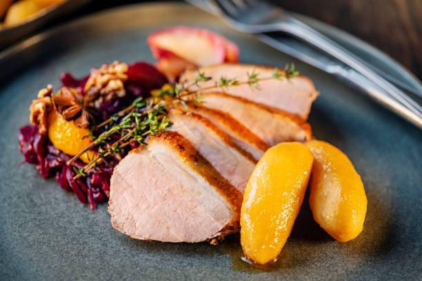 Pork Loin with Red Cabbage and Potatoes Traditional Christmas lunch in Denmark and other Scandinavian countries is roasted pork, here a pork loin, served with red cabbage and a Danish speciality of “brunede kartofler” These are small, round and firm potatoes that have been lightly boiled and peeled they are then placed in a large skillet and covered in a melted sugar and butter sauce to give them light brown colour and a delicious sweet taste. Please see my other pictures in this series. danish culture stock pictures, royalty-free photos & images