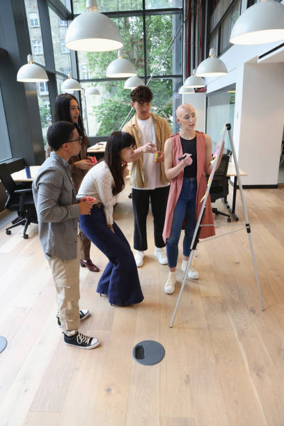 istock Business people looking at whiteboard during meeting 2174421554