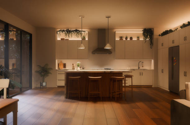 Kitchen interior with island, cabinets, and pendant lights at night