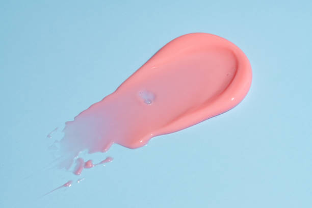 istock pink lip gloss smear stroke on blue background. Make up product texture presentation 2174423743