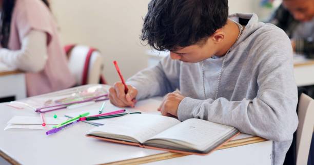 istock Writing, book and student in classroom for learning chemistry with notes for exam, test or project. Education, teenager and boy in lesson for studying science at school academy with scholarship. 2174424551