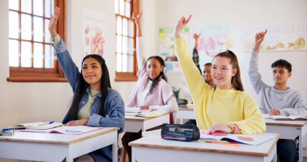 istock Happy children, students or hands raised with question in classroom for interaction, learning or education at school. Young, group or learners with smile or answer for engagement, quiz or development 2174424557