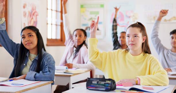 istock Happy teenager, students or hands raised with question in classroom for interaction, learning or education at school. Young, group or learners with smile or answer for engagement, quiz or development 2174424566