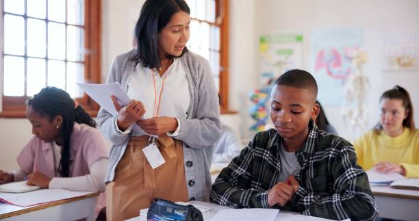 istock Education, teacher and test with students in classroom for learning, scholarship and anatomy. Biology, knowledge and future with people at STEM school for information, development and academy 2174424606