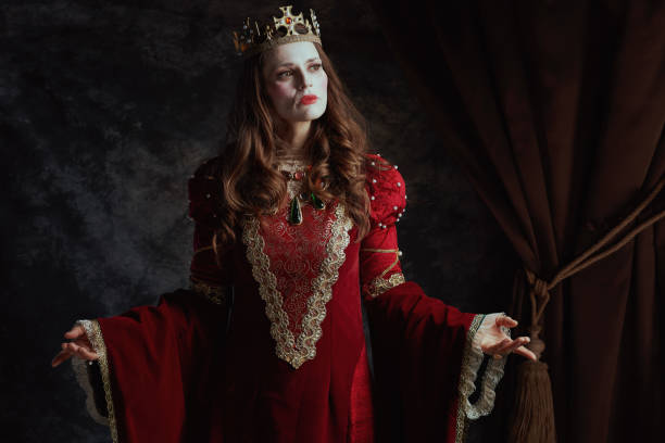 istock medieval queen in red dress with white makeup and crown 2174425565