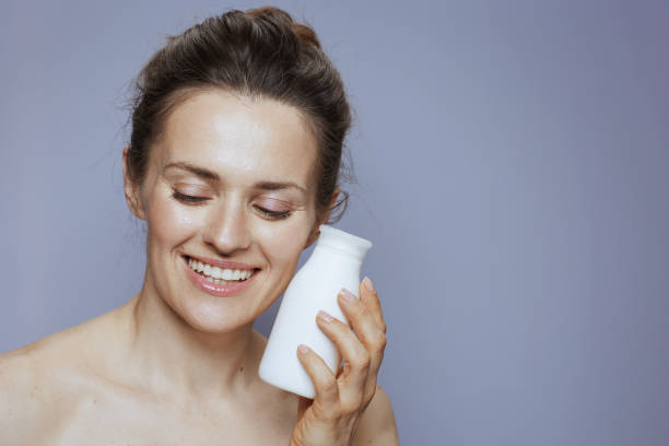 istock smiling woman with cosmetic cream jar 2174425724