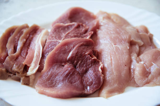Pork, pork belly and turkey treast slices on plate, close up, no people