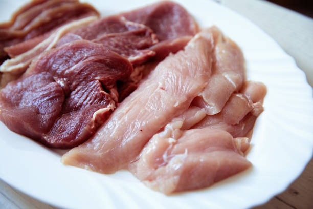 Pork, pork belly and turkey treast slices on plate, close up, no people