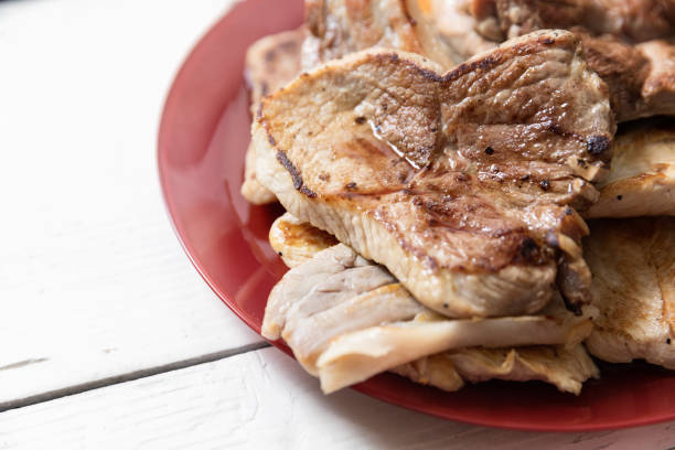 Grilled pork, turkey breast and pork belly slices on plate, close up