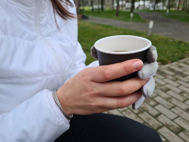 istock A person enjoying a warm beverage while seated outdoors in a park during a chilly day concept 2174426893