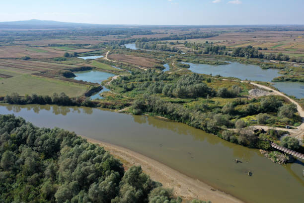 istock Flying over a river flowing on a plain aerial view 2174429230
