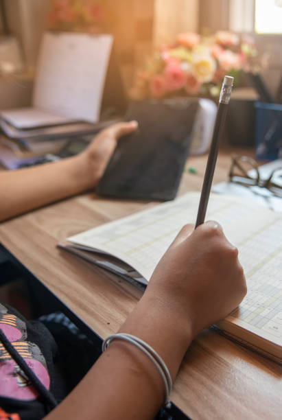istock Planner plan Schedule Calendar and reminder agenda, using tablet. Man hand planning daily appointment and write business trip in diary book at office desk. 2025 Calendar reminder event concept-vertical image. 2174432506