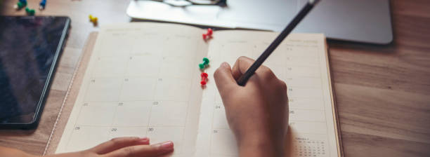 istock Planner plan Schedule Calendar and reminder agenda, using tablet. Man hand planning daily appointment and write business trip in diary book at office desk. 2024 Calendar reminder event concept-banner. 2174432513