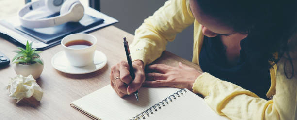 Planner plan Schedule Calendar and reminder agenda, work at home. Man hand planning daily appointment and write business trip in diary book at office desk. 2025 Calendar reminder event concept-banner image.