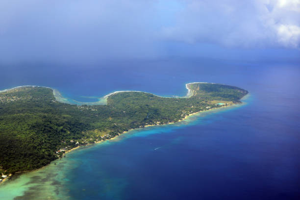 Island of Efate, Vanuatu: aerial view - west part of the island, Mele Bay and Pango Peninsula - Vanuatu, an archipelago in the South Pacific, is highly vulnerable to the impacts of climate change due to its geographical characteristics, including low-lying islands and exposure to extreme weather events. Rising sea levels threaten to submerge coastal areas and freshwater sources, while increased intensity of cyclones, droughts, and heavy rainfall pose risks to agriculture, infrastructure, and local livelihoods. The country's economy, largely dependent on tourism and agriculture, faces significant challenges as ecosystems and natural resources deteriorate. In response, Vanuatu has been proactive in advocating for global climate action, emphasizing the need for sustainable development and resilience-building strategies to protect its communities and environment.