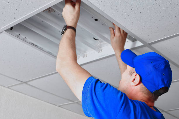 istock Worker repairing ceiling-mounted fluorescent light in commercial space ceiling. 2174436225