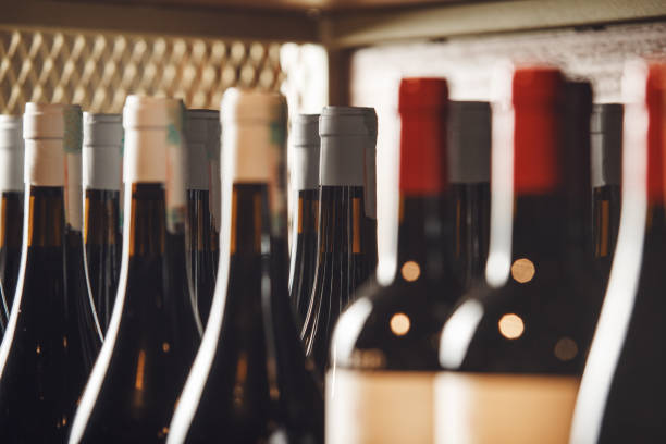 istock Assorted Wine Bottles Lined Up on Shelf in Cozy Wine Shop 2174436544