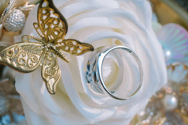 istock A wedding ring adorned with a delicate white rose and butterfly motif crafted from gold, symbolizing eternal love and the beauty of union. 2174437582
