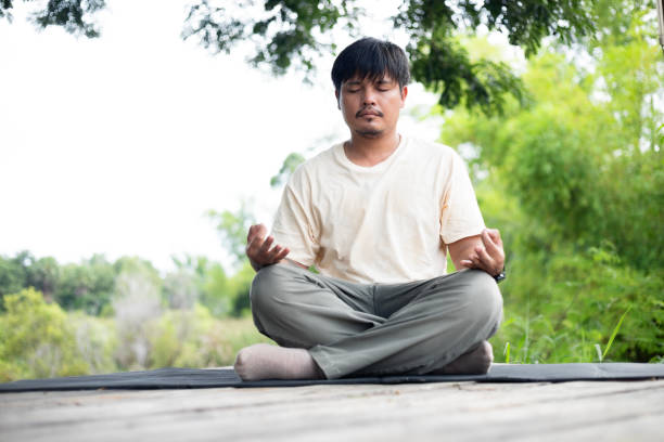 istock A man is sitting on a mat in a park, meditating 2174438283