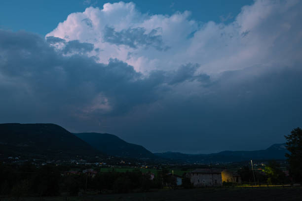 Evening view of tall Cumulonimbus storm clouds over the southern limestone Alps, north of Verona, Italy.