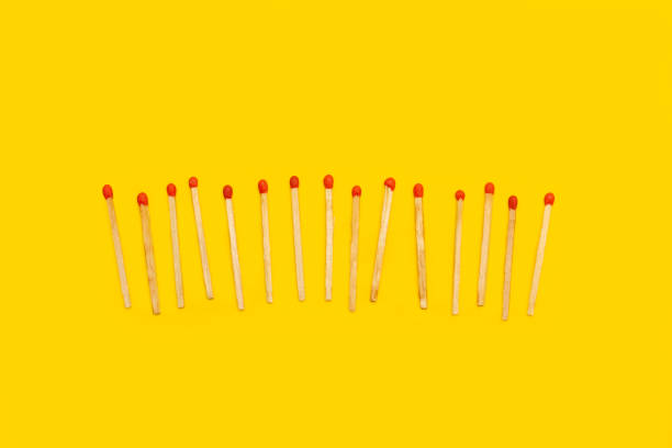 Wooden matches sticks on a yellow background with copy space