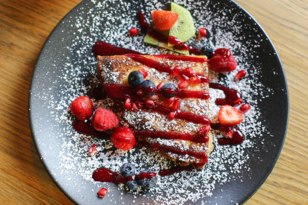 istock Pancake with mascarpone on a plate. Wooden table fine dining. Topped with powdered sugar, fresh fruits, blueberries, raspberries. 2174443113