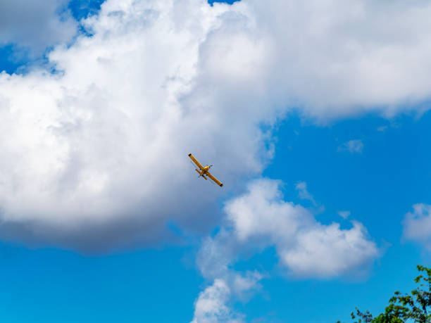 istock Yellow crop dusting aircraft flying over crops 2174445419