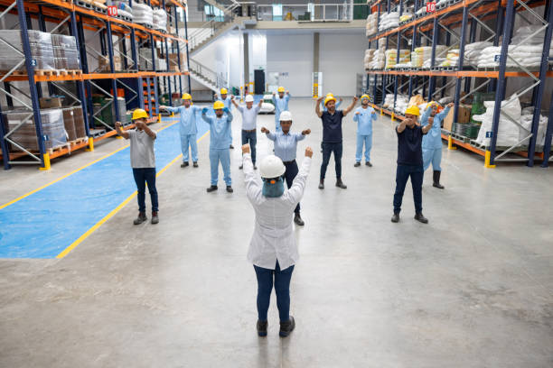 istock Warehouse worker in a wellness meeting doing stretching exercises 2174449797