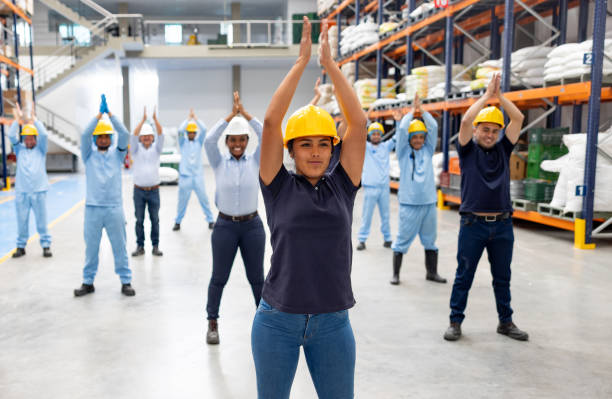 istock Fitness instructor guiding stretching exercises with a group of warehouse workers 2174449807