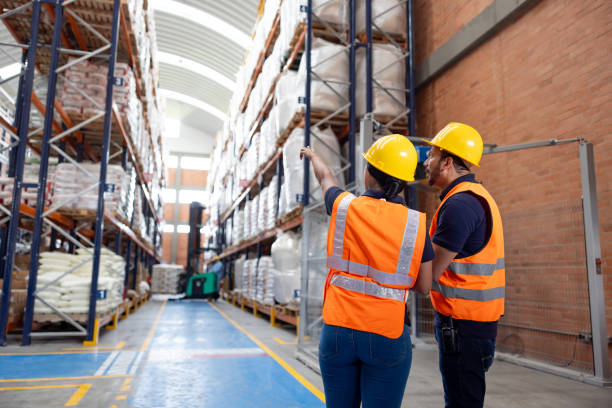 istock Employees working at a distribution warehouse and pointing at the merchandise 2174449861