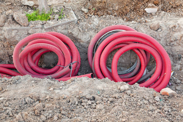 istock Laying communications in the ground using red corrugated hoses. 2174451534