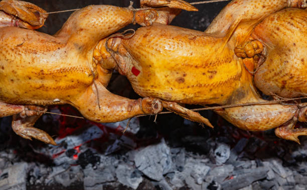 istock Chicken carcasses are roasted on a spit over coals. 2174451554