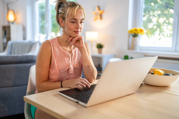 istock Young female entrepreneur focused on data analysis with laptop in daytime environment 2174452251