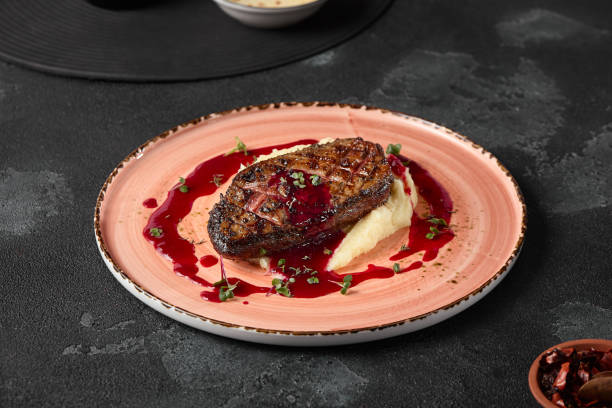istock Gourmet Duck Fillet with Berry Sauce and Mashed Potatoes on Rustic Pink Plate 2174457177