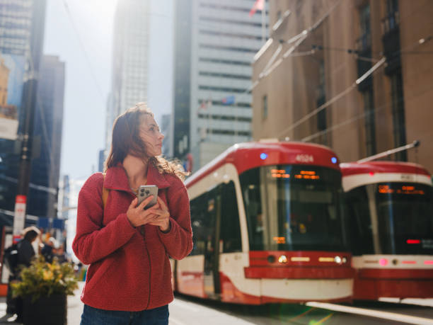 istock Woman using smartphone waiting for the tramway in Toronto 2174457696