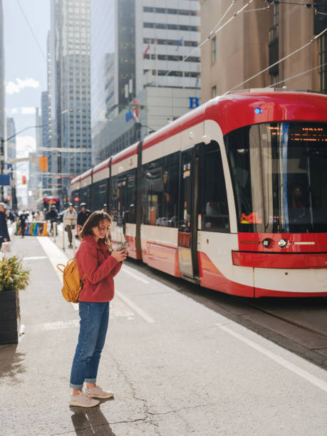 istock Woman using smartphone waiting for the tramway in Toronto 2174457747