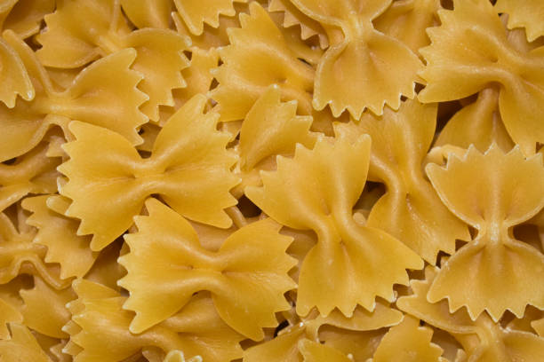 Pasta Farfalle background. Pasta textured background for menu, website, postcard, decoration. Pasta traditional Italian pasta, top view close up