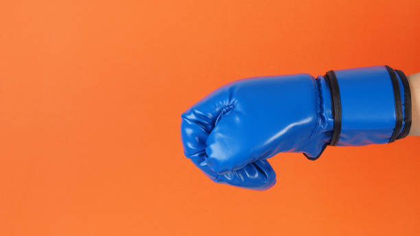 istock Hand wear blue Boxing gloves on orange background. 2174459418