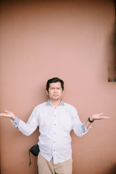 istock Man raises hand in questioning gesture, seeking answers 2174461113