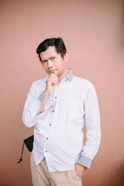 istock A man holding his chin with a puzzled expression, conveying curiosity or surprise 2174461199