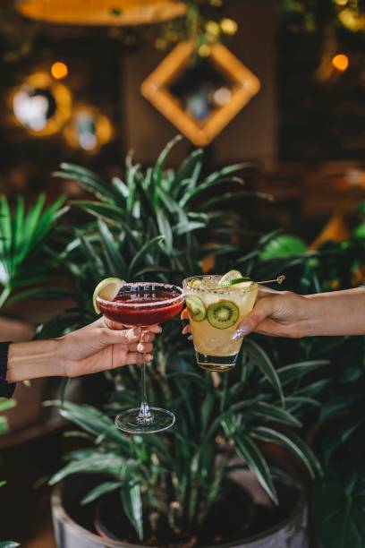 Celebrating with colorful cocktails amidst lush greenery in a cozy setting