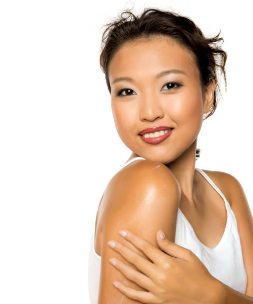 istock Young asian woman applying cream on bare shoulders. 2174467809
