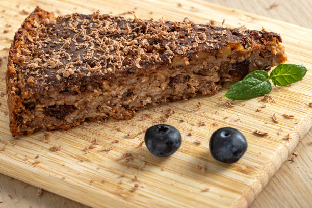 Oat, apple and raisin cake with chocolate - on wooden cutting board, close up view