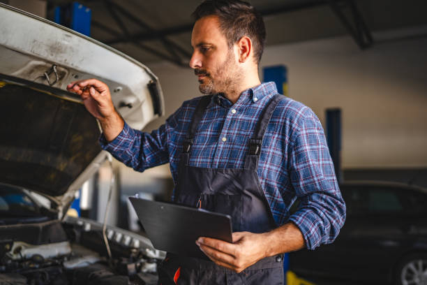 istock Car mechanic inspect car engine and take notes on a clipboard 2174469039