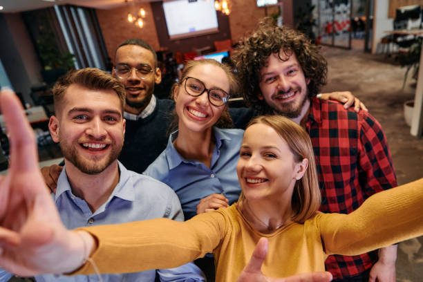 istock A diverse group of business professionals take a break from their tasks in a modern startup office to capture a creative selfie, showcasing teamwork and a vibrant workplace culture 2174477272