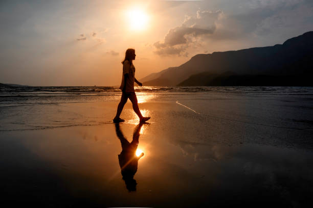 istock Young woman walking on the beach at sunset. 2174480137