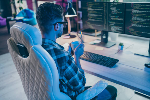 istock Photo of thoughtful busy programmer wear spectacles drinking tea thinking working modern device indoors workplace workshop home 2174480179