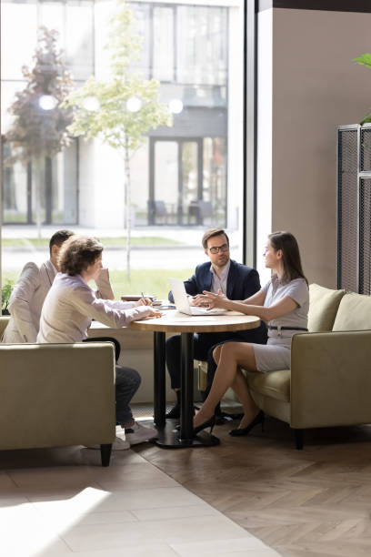 istock Business partners discussing deal in co-working space, sitting on couches 2174480704