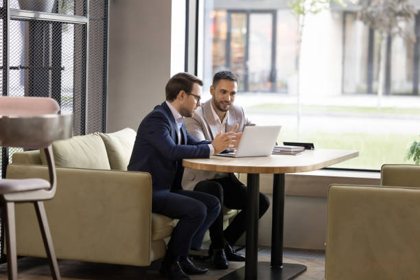 istock Two engaged business partners talking at laptop in office cafe 2174481727