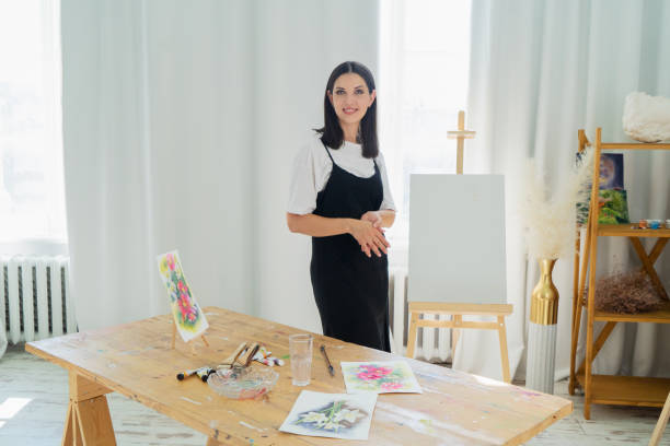 istock A Creative Artist is diligently at work in a bright and vibrant studio surrounded by stunning floral paintings 2174483201